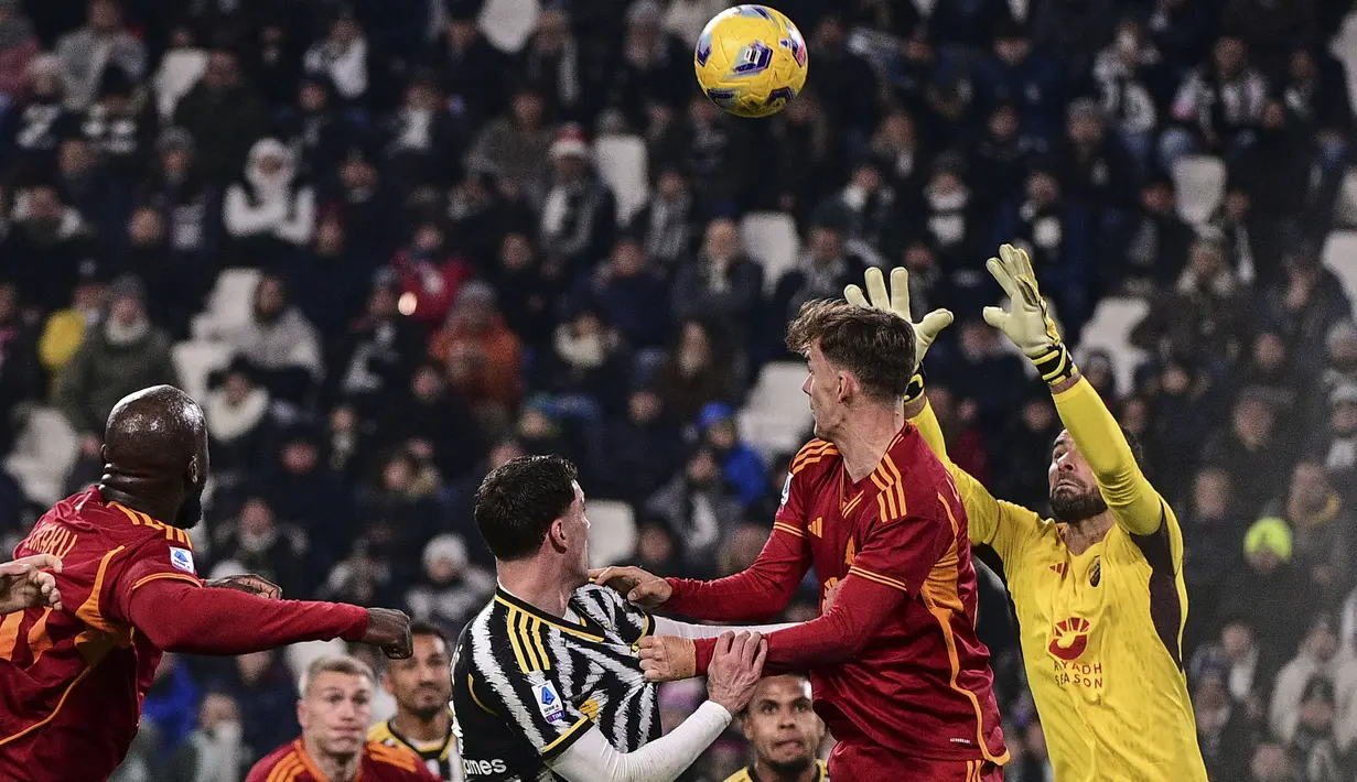 Kiper AS Roma, Rui Patricio (kanan) berusaha menangkap bola dari ancaman striker Juventus, Dusan Vlahovic (tengah) pada laga pekan ke-18 Serie A Liga Italia 2023/2024 di Allianz Stadium, Turin, Sabtu (30/12/2023) malam waktu setempat. (LaPresse via AP Photo/Marco Alpozzi)