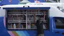 Seorang anak sedang mengambil buku di mobil Perpustakaan Keliling Dinas Perpustakaan dan Arsip Daerah Kabupaten Klungkung di lokasi pengungsian korban evakuasi Gunung Agung, Klungkung, Bali, Sabtu (30/09). (Liputan6.com/Gempur M Surya)