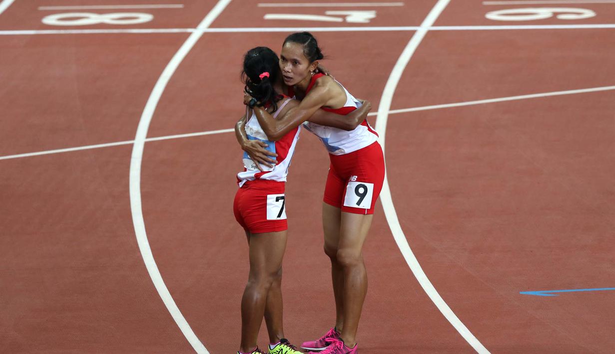 Triyaningsih berpelukan dengan pelari Indonesia lainnya, Rini Budiarti, yang meraih medali perak. (Bola.com/Arief Bagus)