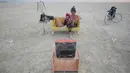 Jody Friedman dan Jeff Montgomery mengeksplorasi karya seni dengan cara menonton televisi di Festival Burning Man, di padang pasir Black Rock, Nevada, Amerika Serikat (30/08). (REUTERS/Jim Urquhart)