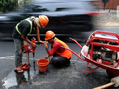 Pekerja mengebor aspal yang menutup sumur resapan di Jalan Lebak Bulus III, Cilandak, Jakarta Selatan, Senin (6/12/2021). Sebanyak 29 sumur resapan yang tertutup aspal kembali dilubangi agar bisa bisa menampung air saat curah hujan tinggi. (merdeka.com/Arie Basuki)