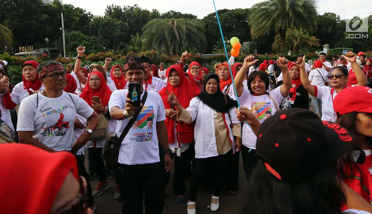 Ratusan relawan Jokowi Poros Benhil melakukan aksi damai salam jempol ceria di kawasan Monas, Jakarta, Jumat (11/1). Aksi digelar sebagai antisipasi menghilangkan rasa ketakutan, sara, hoaks, dan premanisme masyarakat. (Liputan6.com/Johan Tallo)