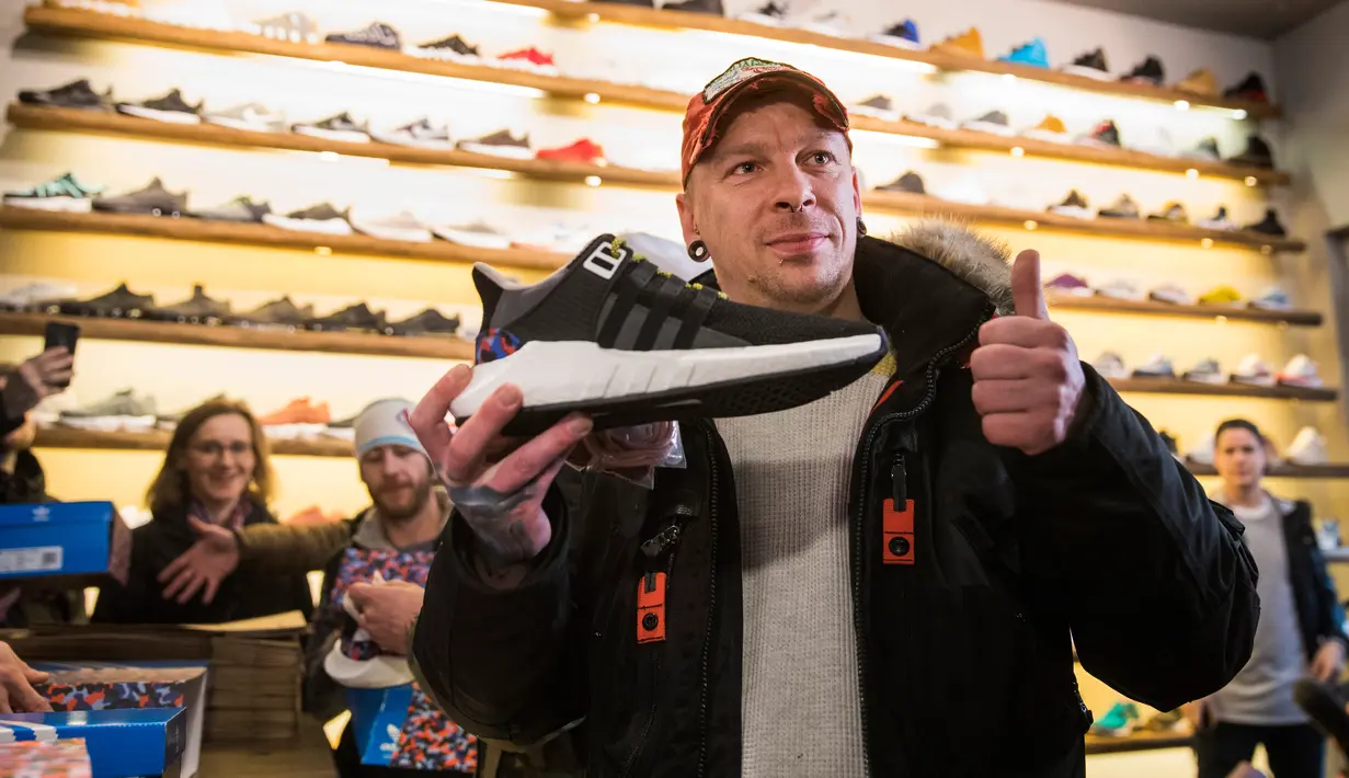 Pembeli pertama sepatu olahraga Adidas/BVG (Berlin Transport), Steven, di toko Overkill di Berlin, Jerman, Selasa (16/1). Sepatu yang disebut-sebut paling canggih tersebut dijual dengan harga 180 Euro atau sekitar Rp 2,95 juta. (AFP PHOTO / Odd ANDERSEN)