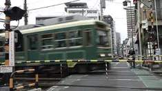 Seorang wanita yang mengenakan masker pelindung untuk membantu mengekang penyebaran virus corona dengan sepeda menunggu di perlintasan kereta di Tokyo, Selasa (26/1/2021). Jepang mengonfirmasi lebih dari 1.000 kasus Virus Corona baru pada 26 Januari 2021. (AP Photo/Eugene Hoshiko)