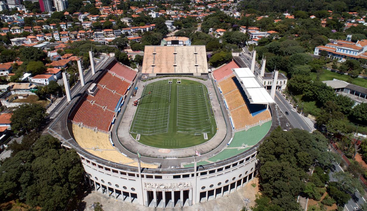 Pekerja membangun rumah sakit darurat bagi pasien terinfeksi Covid-19 di lapangan stadion Pacaembu, di Sao Paulo, Senin (23/3/2020). Sejumlah klub sepakbola papan atas Brasil meminjamkan stadion ke otoritas setempat untuk diubah menjadi rumah sakit atau klinik darurat virus corona. (AP/Andre Penner)
