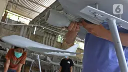 Pekerja menyelesaikan pembuatan miniatur pesawat di workshop Anglo Indonesian Aircraft Models di Cibinong, Kabupaten Bogor, Kamis (15/10/2020). Sebuah miniatur pesawat ini dijual seharga Rp250 ribu hingga Rp 50 juta tergantung skalanya. (Liputan6.com/Herman Zakharia)
