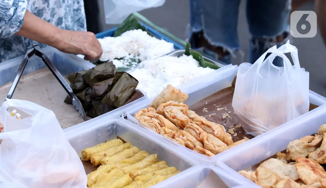 Pedagang menyiapkan makanan untuk berbuka puasa di kawasan Bendungan Hilir, Jakarta, Sabtu (25/4/2020). Meski ditengah pandemi virus Covid-19, masyarakat masih antusias berburu penganan berbuka puasa dengan tetap menerapkan pola jaga jarak dan memakai masker. (Liputan6.com/Helmi Fithriansyah)