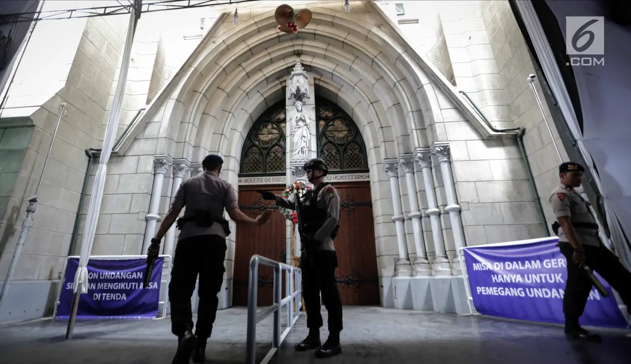 Personel Gegana dan K9 Polda Metro Jaya berdiri di depan pintu Gereja Katedral saat melakukan penyisiran, Jakarta, Minggu (24/12). Sterilisasi ini dilakukan untuk menjamin rasa aman umat kristiani saat menjalankan ibadah Natal.(Liputan6.com/Faizal Fanani)