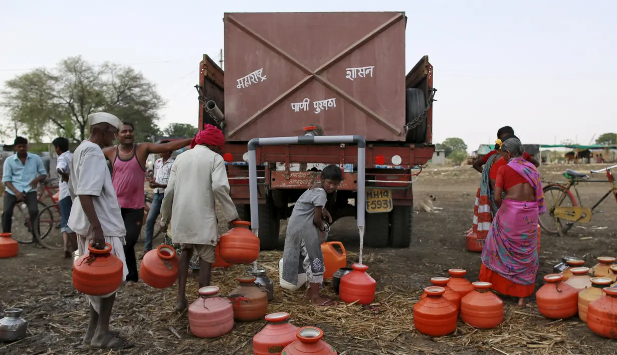Warga mengisi air dari truk tangki bantuan pemerintah di sebuah desa di Osmanabad, India, (15/4). Sejumlah wilayah di India mengalami kesulitan air bersih karena kekeringan akibat kemarau panjang melanda negerinya. (REUTERS/Danish Siddiqui)
