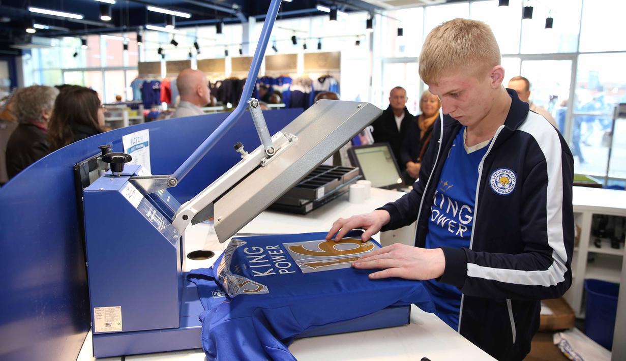 Seorang staf sedang mempersiapkan jersey tim untuk dijual dengan tulisan "Champions". (3/5/2016). (Action Images via Reuters/Matthew Childs)