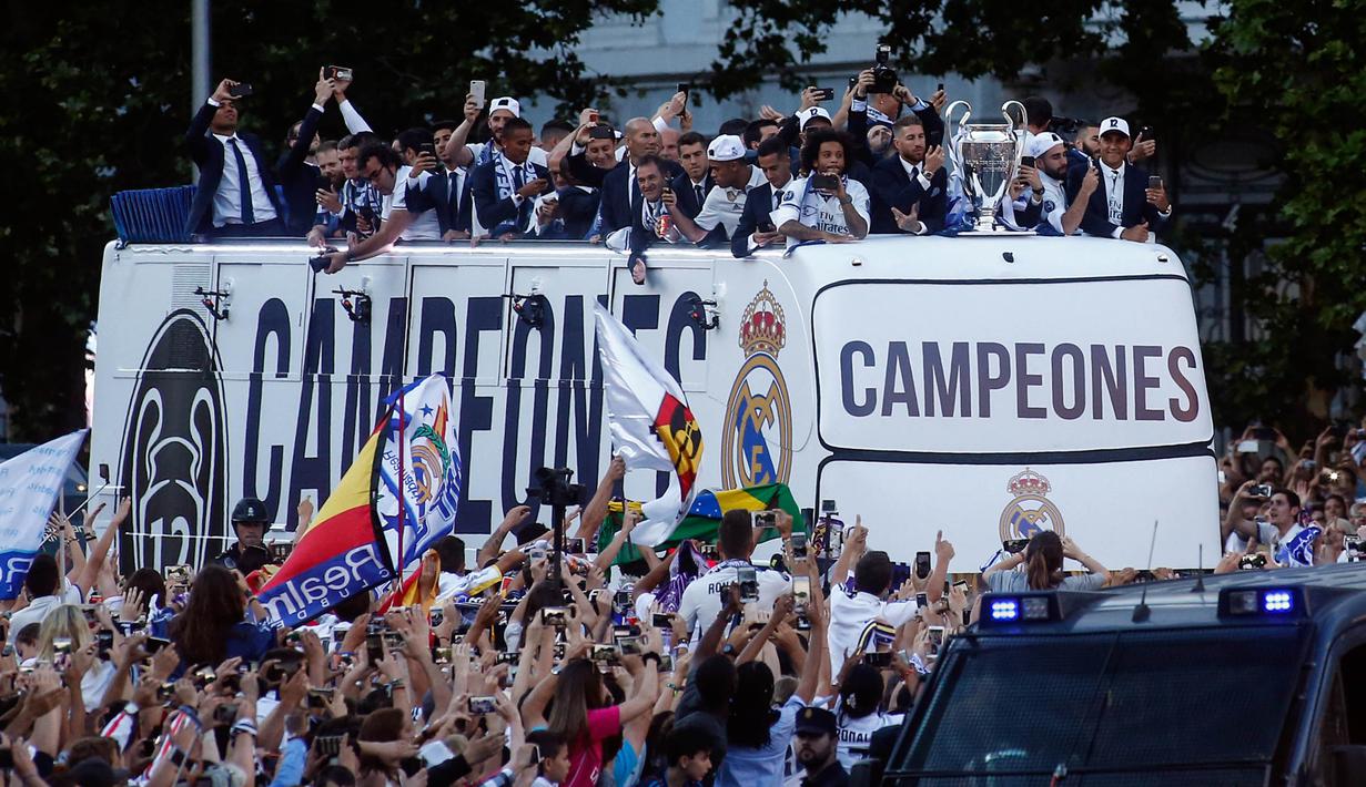 Pemain Real Madrid berkeliling kota Madrid saat merayakan keberhasilan meraih gelar ke-12 Liga Champions di Stadion  Santiago Bernabeu, Madrid, Spanyol (4/6). Real Madrid menjadi juara usai mengalahkan Juventus 4-1. (AFP/ Oscar Del Pozo)