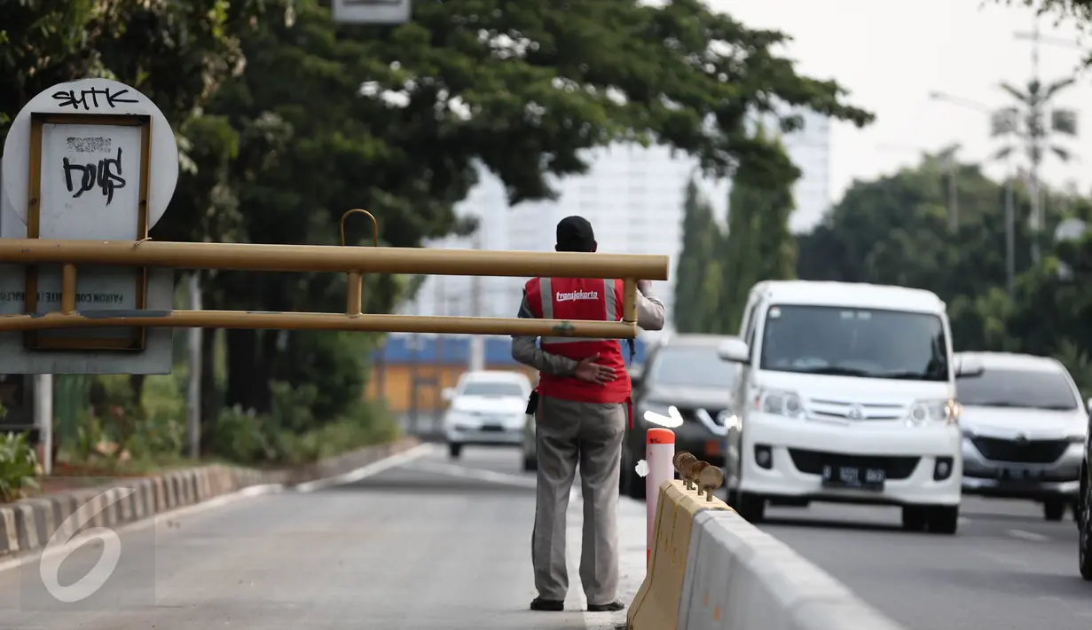 Petugas TransJakarta menjaga jalur busway dikawasan Pramuka, Jakarta, Minggu (12/6/2016). Pemprov DKI Jakarta akan melakukan sterilisasi jalur Trans Jakarta mulai Senin nanti (13/6). (Liputan6.com/Faizal Fanani)
