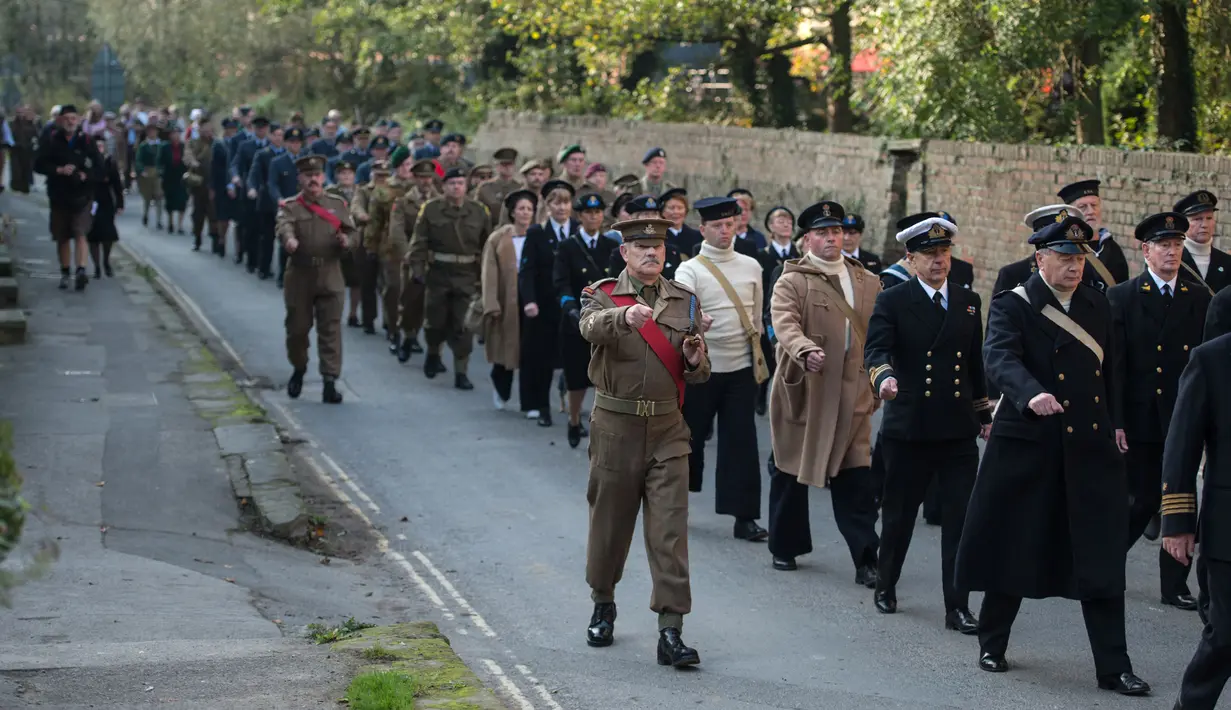 Sejumlah Reenactor Perang Dunia II mengenakan pakaian tentara berbaris saat mengikuti 'Railway in Wartime Event' yang ke 25 di Pickering, Inggris (15/10). (AFP Photo/Oli Scarff)