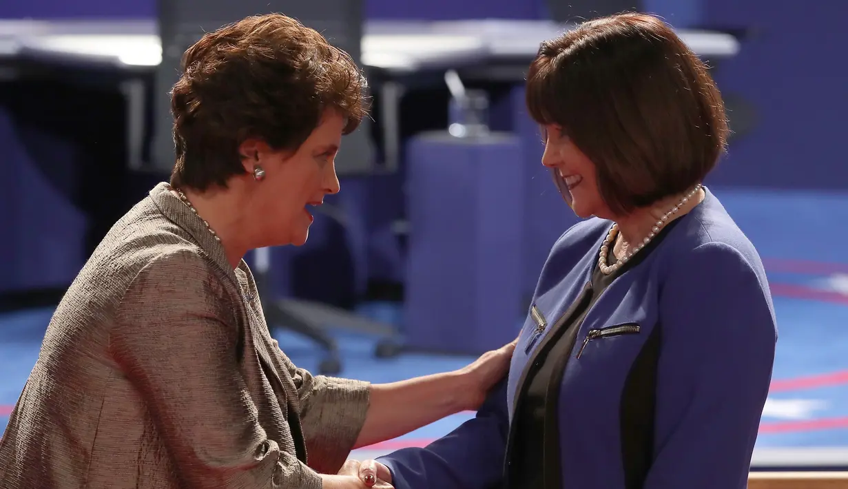 Anne Holton berjabat tangan dengan Karen Pence menjelang dimulainya debat cawapres AS di Longwood University, Virginia, Selasa (4/10). Debat yang mempertemukan dua cawapres AS, Tim Kaine dan Mike Pence berlangsung cukup tegang. (AFP/Mark Wilson)