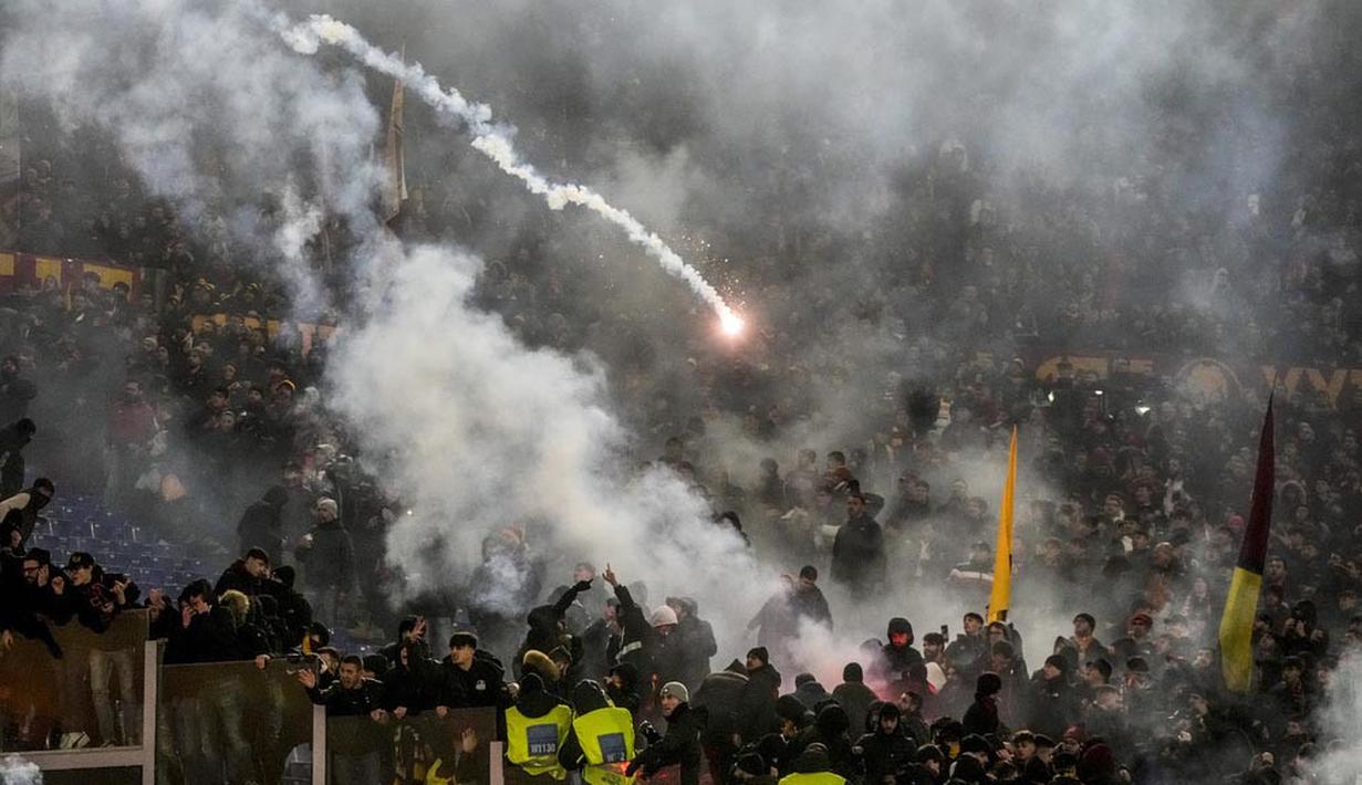 Suporter Lazio dan AS Roma saling melempar flare pada laga perempat final Coppa Italia 2023/2024 di Stadio Olimpico, Kamis (11/1/2024). Laga panas tersebut dihiasi tiga kartu merah, flare hingga keributan antar pemain dan suporter. (AP Photo/Gregorio Borgia)