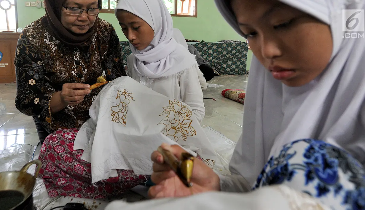 Pengajar dari Komunitas Batik Cibuluh memberikan pelatihan membatik kepada muird SLB Mekar Sari 1 Cibinong, Bogor, Jawa Barat, Rabu (18/9/2019). Ekstrakurikuler yang rutin dilaksanakan seminggu sekali ini untuk membekali para siswa keterampilan membatik. (merdeka.com/Arie Basuki)