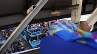 Seorang ibu menyambut pemain Persib Bandung dari jembatan penyeberangan saat berlangsungnya Pawai Persib Juara Piala Presiden, Minggu (25/10/2015). (Bola.com/Nicklas Hanoatubun)