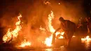 Sesaat sebelum tengah malam, mereka kembali ke alun-alun desa untuk menyalakan api unggun dengan melemparkan tong-tong yang telah dibakar. (Oli SCARFF/AFP)