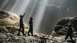 Daya tarik utama tempat ini adalah fenomena “Cahaya Surga” yang muncul di Luweng Grubug. Sekitar pukul 10.00 hingga 12.00 WIB, sinar matahari menembus celah gua dan memantul pada batu flowstone, menciptakan pancaran cahaya vertikal yang menakjubkan. Pemandangan ini hanya bisa disaksikan saat cuaca cerah dan menjadi momen paling dinanti oleh para penjelajah maupun fotografer. Tampak dalam foto, pemandu goa memberikan penjelasan kepada wisatawan di dalam Goa Jomblang  di Gunung Kidul, Yogyakarta. (merdeka.com/Arie Basuki)