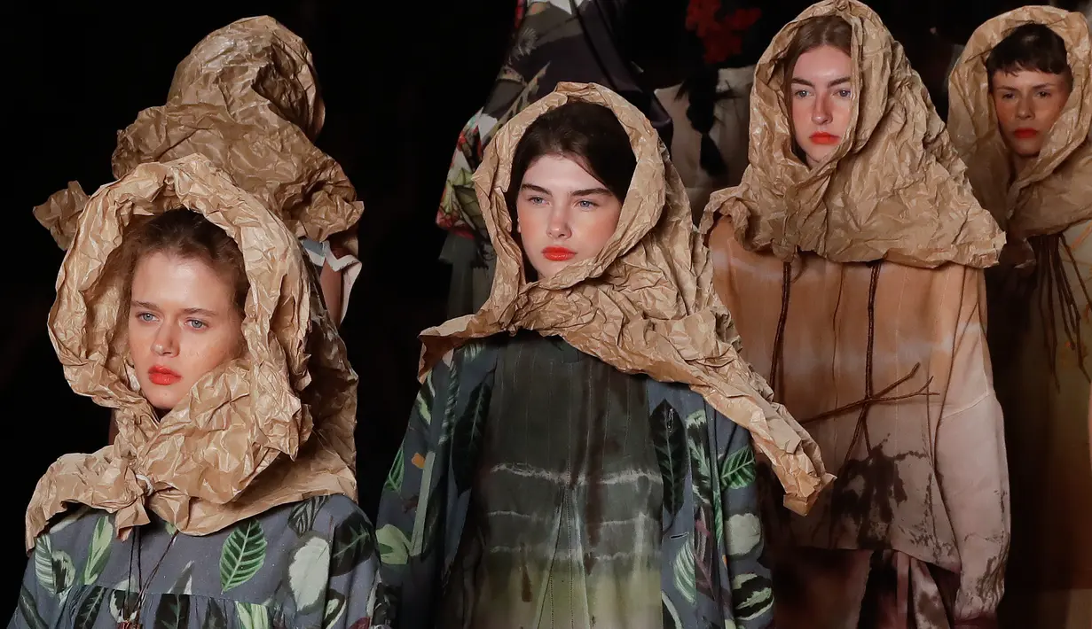 Sejumlah model mengenakan kertas cokelat atau yang biasa disebut kertas pembungkus saat membawakan rancangan karya Ronaldo Fraga dalam Sao Paulo Fashion Week di Brasil (26/4). (AP Photo / Andre Penner)