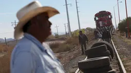 Petani menggunakan ban untuk memblokade rel kereta api di Villa Ahumada, Meksiko, Kamis (12/11). Dalam aksinya, anggota organisasi petani Meskiko "El Barzon" menuntut pemerintah untuk menurunkan harga bbm, pupuk dan listrik (REUTERS/Jose Luis Gonzalez)