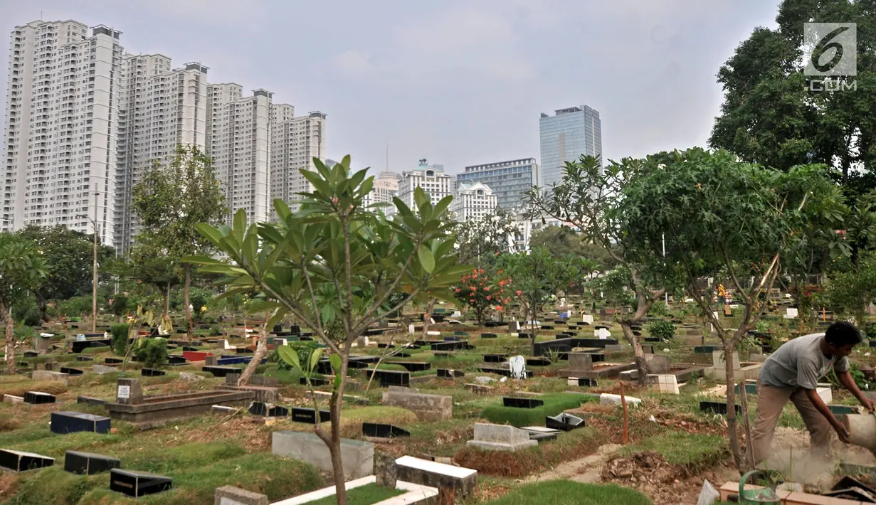 Petugas membersihkan makam di TPU Karet Bivak, Jakarta, Kamis (12/7). Di TPU Karet Bivak banyak dijumpai makam bertumpuk hingga empat jenazah dalam satu makam. (Merdeka.com/Iqbal Nugroho)
