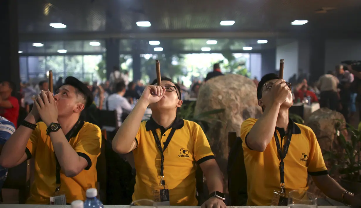 Peserta asal Tiongkok berkompetisi dalam lomba membuat sisa abu cerutu terpanjang di Festival Habanos tahunan XVIII di Havana, Kuba, (3/3) Peserta dituntut mempertahankan sisa abu cerutu yang mereka hisap hingga panjang. (REUTERS/Alexandre Meneghini)