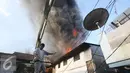 Warga berusaha memadamkan api yang membakar pemukiman penduduk di Tanah Abang, Jakarta, Senin (5/9). Sebanyak 25 unit pemadam kebakaran telah diterjunkan untuk memadamkan api yang membakar kawasan padat penduduk tersebut. (Liputan6.com/Immanuel Antonius)