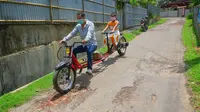Partha Saha (depan), seorang montir pembuat kendaraan rakitan memodifikasi motor untuk melakukan jaga jarak sosial. Sebagai langkah pencegahan terhadap penyebaran Corona COVID-19 di India. (Xinhua)