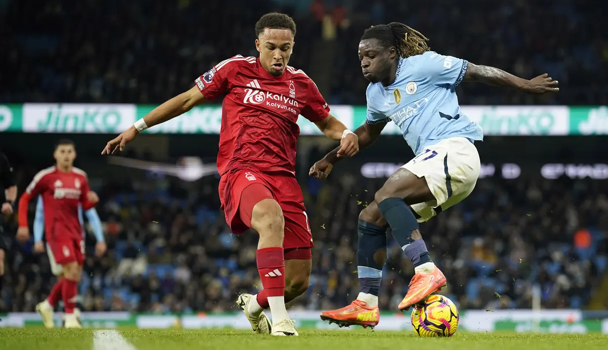 <p>Pemain Manchester City, Jeremy Doku (kanan) berebut bola dengan pemain Nottingham Forest, Eric da Silva Moreira pada laga lanjutan Liga Inggris 2024/2025 di Etihad Stadium, Manchester, Inggris, Kamis (05/12/2024). (AP Photo/Martin Rickett)</p>
