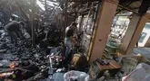 Sejumlah pedagang mengais puing dan sisa barang dagangan yang hangus terbakar di Pasar Taman Puring, Jakarta Selatan, Selasa (29/7/2025). (merdeka.com/Arie Basuki)