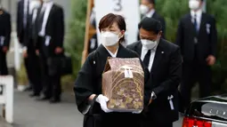 Akie Abe, istri mantan Perdana Menteri Shinzo Abe, membawa guci berisi abu mendiang suaminya saat tiba di tempat pemakaman kenegaraan di Nippon Budokan, Tokyo, Jepang, Selasa (27/9/2022). Biaya tersebut mencakup 800 juta Yen (Rp 83,9 miliar) untuk keamanan dan 600 juta Yen (Rp 62,9 miliar) untuk menjamu delegasi asing. (Kiyoshi Ota/Pool Photo via AP)