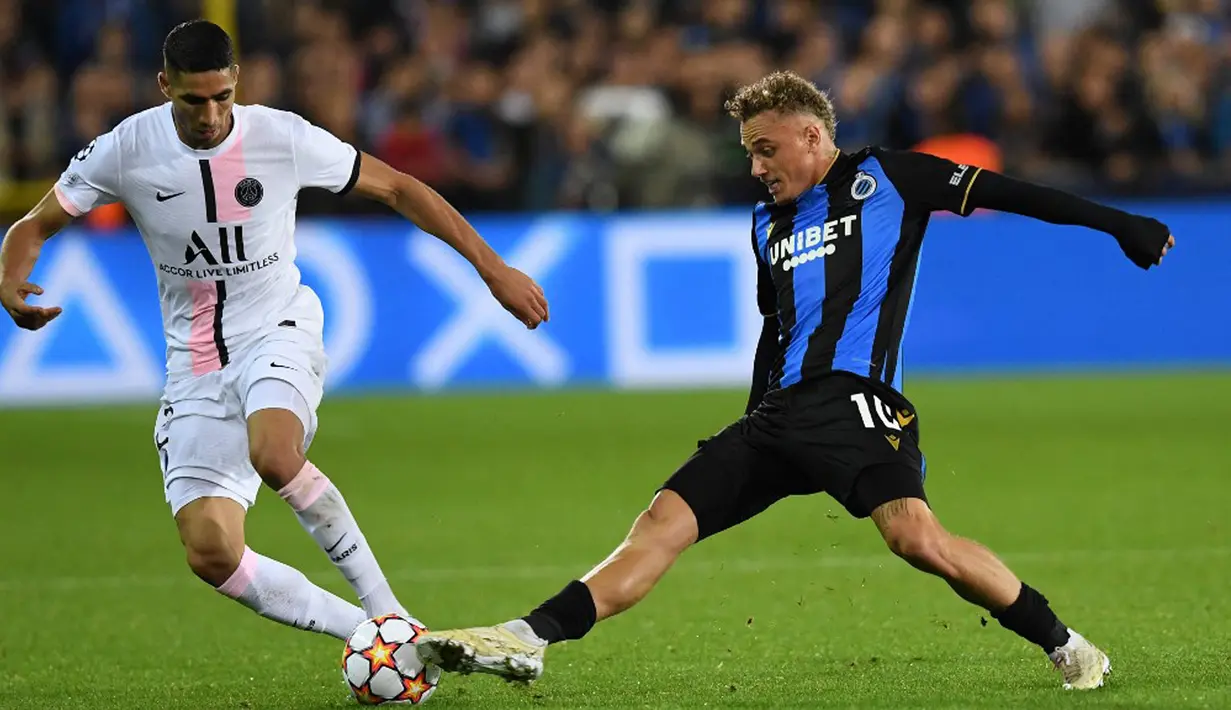 Pemain Club Brugge Noa Lang berebut bola dengan pemain Paris Saint-Germain Achraf Hakimi (kiri) pada pertandingan Grup A Liga Champions di Stadion Jan Breydel, Bruges, Belgia, Rabu (15/9/2021). Pertandingan berakhir imbang 1-1. (JOHN THYS/AFP)