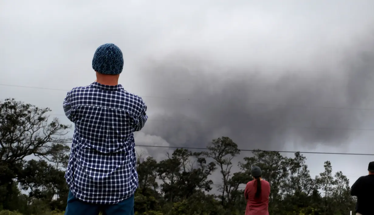 Joe Laceby (47) menyaksikan asap tebal yang berembus dari puncak gunung berapi Kilauea di Hawaii. Kamis (17/5). Para wisatawan tetap santai dan justru menjadikan letusan gunung ini sebagai objek wisata. (AP Photo/Caleb Jones)