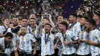 Pemain Argentina Lionel Messi memegang trofi saat dia merayakan dengan rekan satu timnya setelah memenangkan pertandingan sepak bola Finalissima antara Italia dan Argentina di Stadion Wembley, London, Inggris, 1 Juni 2022. Argentina menang 3-0. (AP Photo/Matt Dunham)