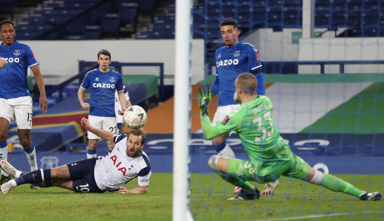 Striker Tottenham Hotspur, Harry Kane (tengah) melepaskan tendangan yang mampu dimentahkan kiper Everton, Robin Olsen dalam laga babak kelima Piala FA 2020/21 di Goodison Park, Rabu (10/2/2021). Tottenham kalah 4-5 (4-4) dari Everton melalui extra time. (AFP/Clive Brunskill/Pool)