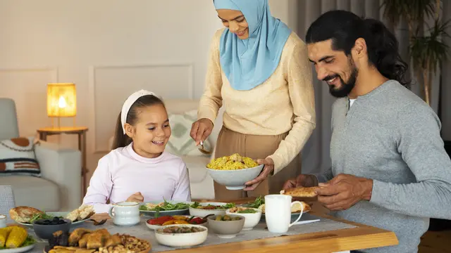 Sebuah keluarga muslim yang terdiri dari ayah, ibu, dan seorang anak sedang makan bersama (Foto Dok: Freepik/freepik)