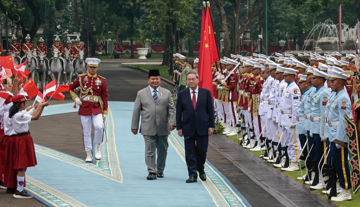 Presiden Republik Indonesia Prabowo Subianto (kiri tengah) dan Perdana Menteri China Li Qiang memeriksa pasukan kehormatan saat upacara penyambutan di Istana Kepresidenan, Jakarta pada 25 Mei 2025. (YASUYOSHI CHIBA/AFP)