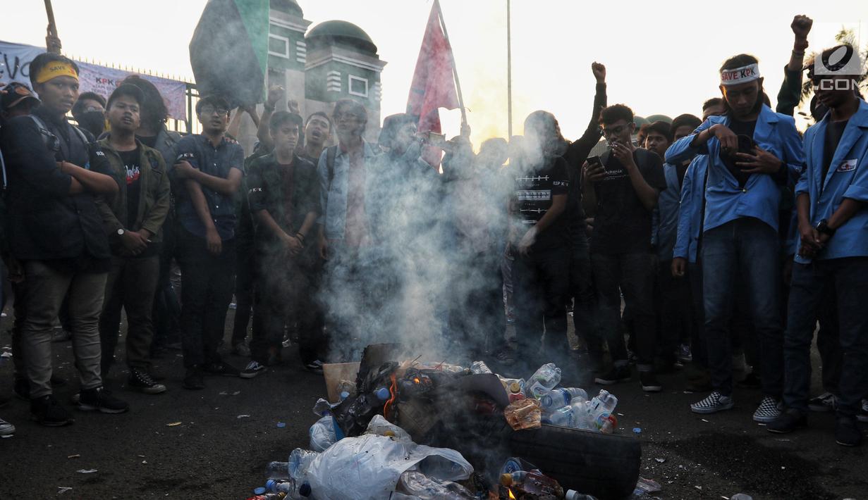 Mahasiswa dari berbagai kampus membakar botol plastik saat menggelar demonstrasi di Gedung DPR/MPR, Jakarta, Kamis (19/9/2019). Demonstrasi mahasiswa yang menolak RKUHP dan UU KPK yang baru disahkan tersebut menyebabkan lalu lintas tersendat. (Liputan6.com/JohanTallo)