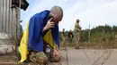 Seorang prajurit Ukraina menelepon setelah dibebaskan dari tawanan Rusia di sebuah lokasi yang dirahasiakan di dekat perbatasan Ukraina-Belarusia, pada 13 September 2024. (Anatolii STEPANOV/AFP)