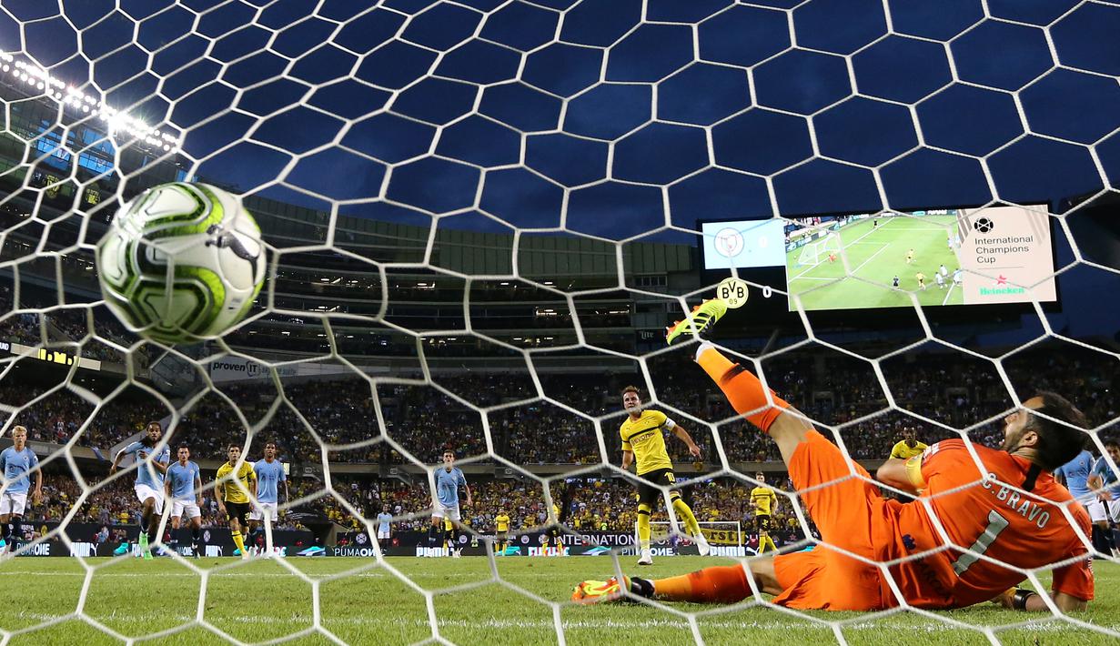 Claudio Bravo gagal mengahalau tendangan penalti Mario Gotze pada laga International Champions Cup 2018 di Soldier Field, Chicago, (20/7/2018), waktu setempat. Drtmund menang 1-0. (Elsa/Getty Images/AFP)