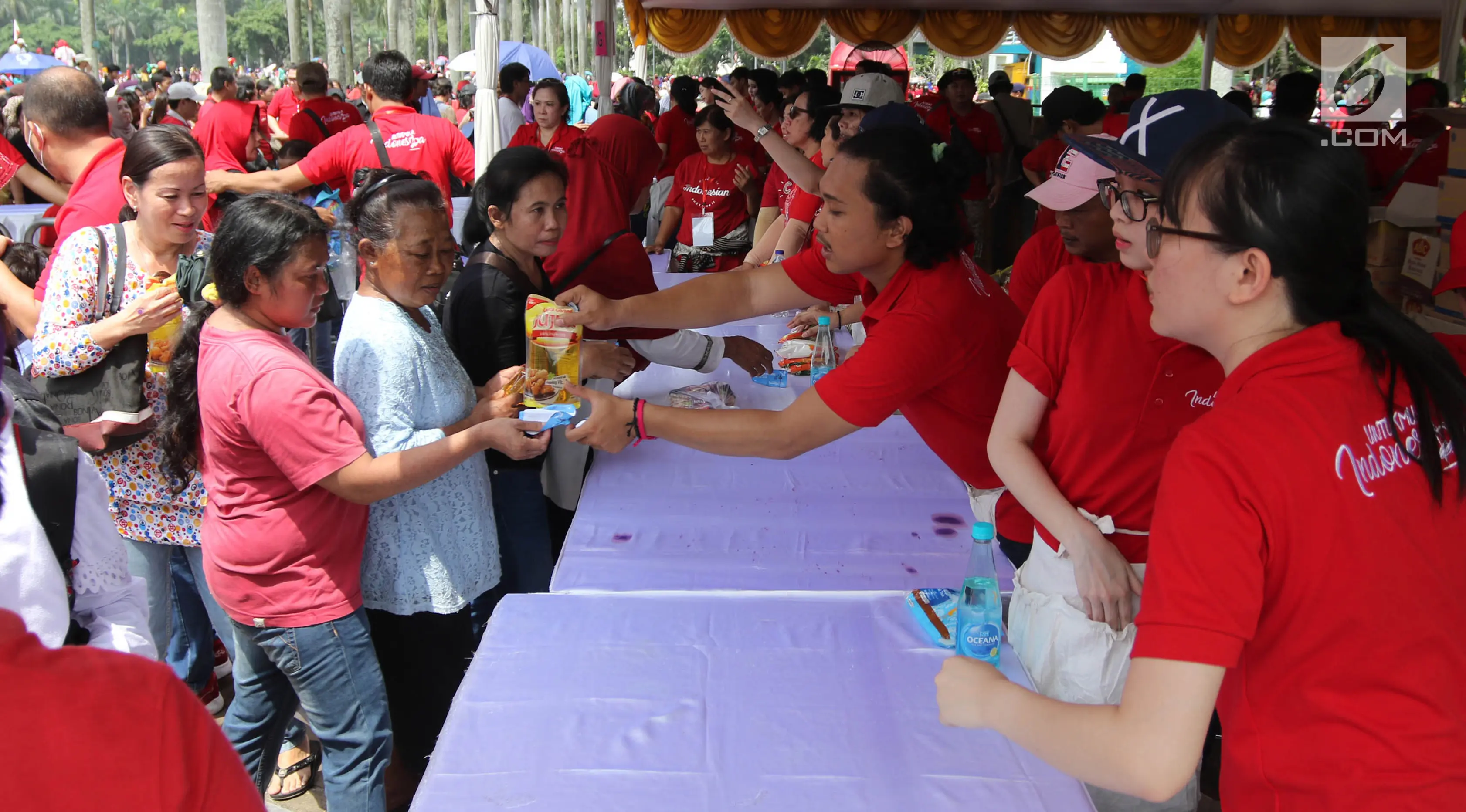 Warga menukarkan kupon untuk mendapatkan sembako gratis dalam acara 