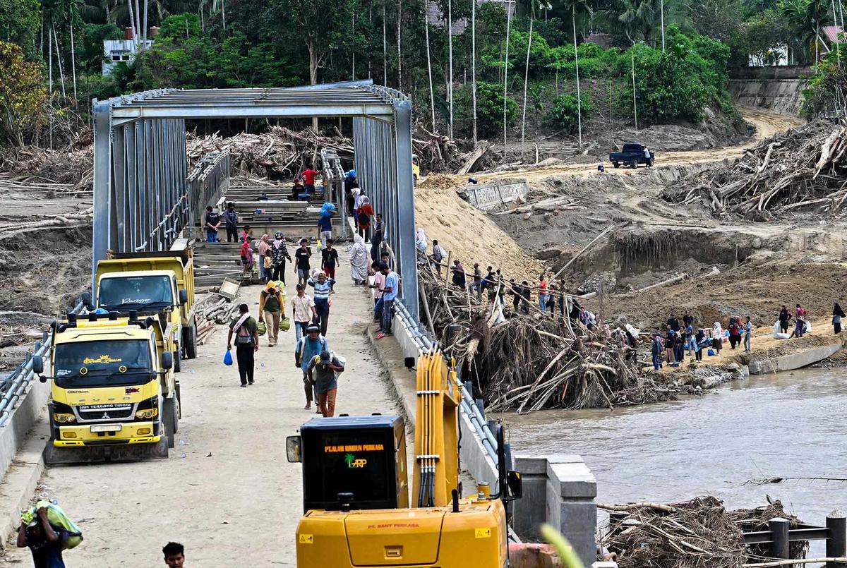 FOTO: Warga Memanjat Puing Kayu Demi Menyeberangi Sungai Peusangan