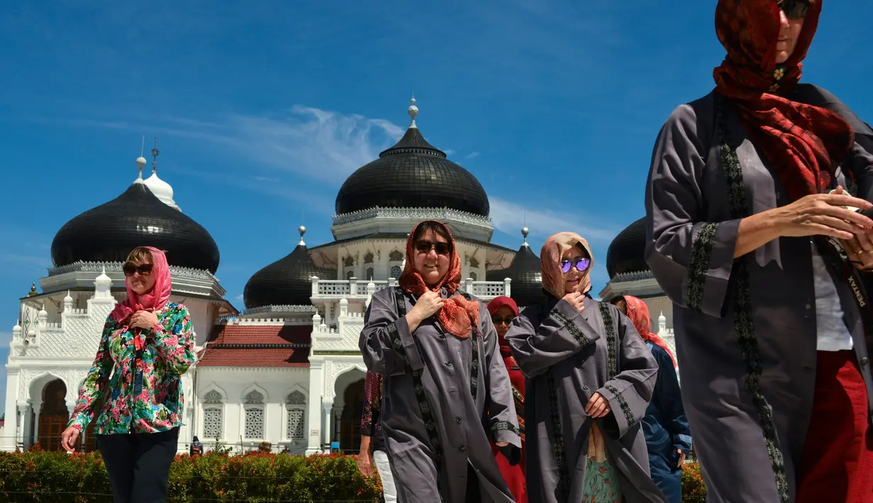 Turis asing mengenakan jilbab saat mengunjungi Masjid Agung Baiturrahman di Banda Aceh, Aceh pada 6 Agustus 2019. Selain sebagai tempat ibadah, Masjid Baiturahman juga menjadi tempat wisata bagi turis lokal dan mancanegara. (CHAIDEER MAHYUDDIN / AFP)