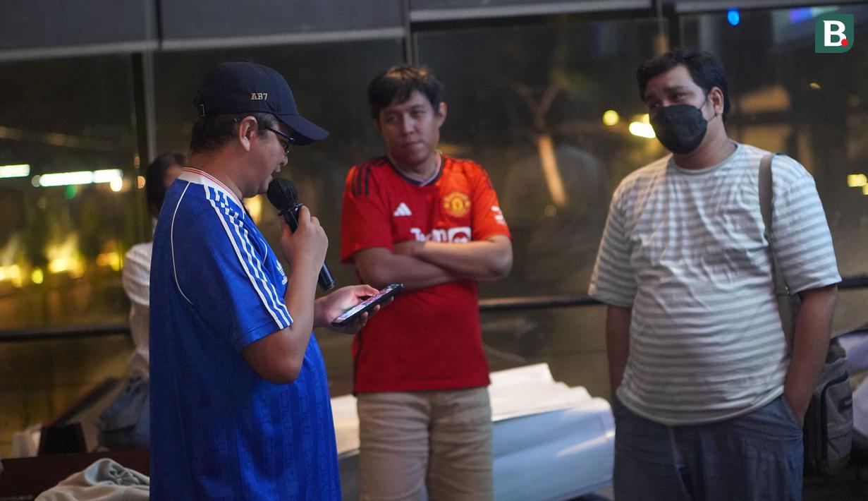 Dua orang anggota komunitas United Army tengah mendengarkan pertanyaan kuis yang dibacakan MC di sela acara Roaring Night pertandingan Liga Inggris 2023/2024 antara Manchester United versus Everton di Brewerkz, The Breeze BSD City, Tangerang, Sabtu (9/3/2024) malam WIB. (Bola.com/Afi)