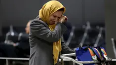Wanita muslim menangis terharu setelah berpergian dari Addis Ababa, Ethiopia setibanya ia di Bandara Dulles, Washington, Senin (6/2). Sejumlah warga muslim sempat tidak dapat masuk AS akibat kebijakan imigrasi Donald Trump. (Win McNamee/Getty Images/AFP)