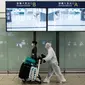 Penumpang mengenakan pakaian pelindung saat tiba di Bandara Internasional Hong Kong, Hong Kong (19/3/2020). Para penumpang di Bandara Hong Kong terpantau memakai perlindungan 'ekstra' lantaran takut tertular virus corona. (AFP/Anthony Wallace)