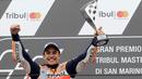 Pembalap Repsol Honda, Marc Marquez memegang trofi juara balapan MotoGP San Marino 2017 di atas podium Sirkuit Misano, Italia, Minggu (10/9). Marquez sukses mencatat waktu 50 menit 41,565 detik, terpaut 1,192 detik. (AP Photo/Antonio Calanni)