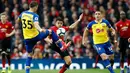 Pemain Southampton, Jan Bednarek berebut bola dengan striker Manchester United, Alexis Sanchez selama pertandingan lanjutan Liga Inggris di stadion Old Trafford, (2/3). MU menang tipis 3-2 atas Southampton. (Martin Rickett /PA via AP)