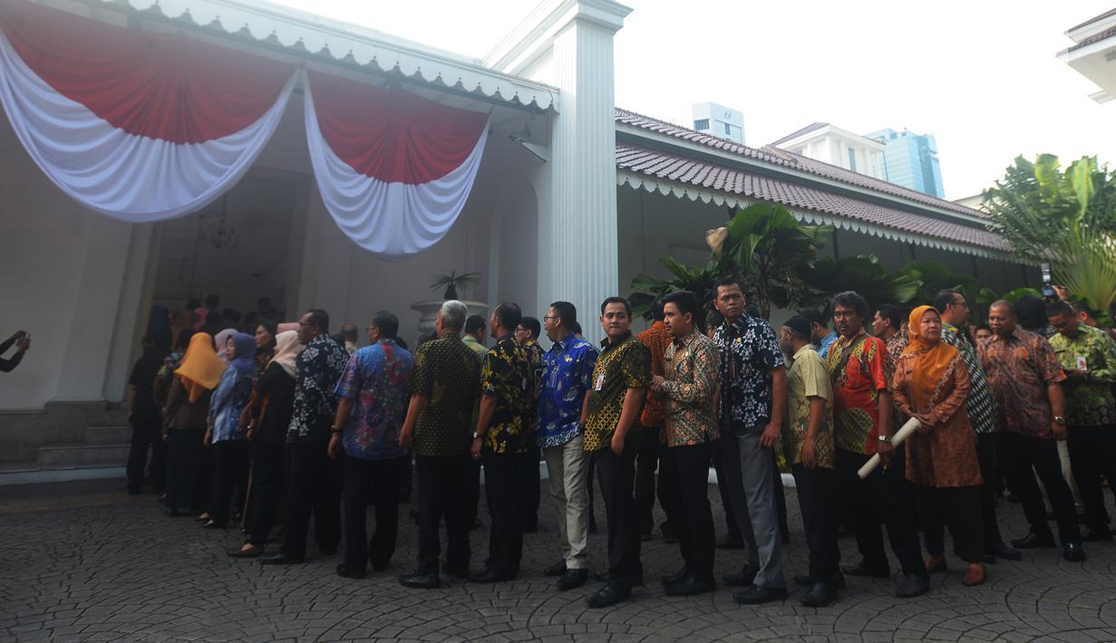 Pegawai Pemprov DKI mengantre pada hari pertama masuk kerja setelah libur Lebaran di Balai Kota, Jakarta, Kamis (21/6). Mereka mengantre bersalaman dengan Gubernur DKI Anies Baswedan dan Wakil Gubernur DKI Sandiaga Uno. (Merdeka.com/Imam Buhori)